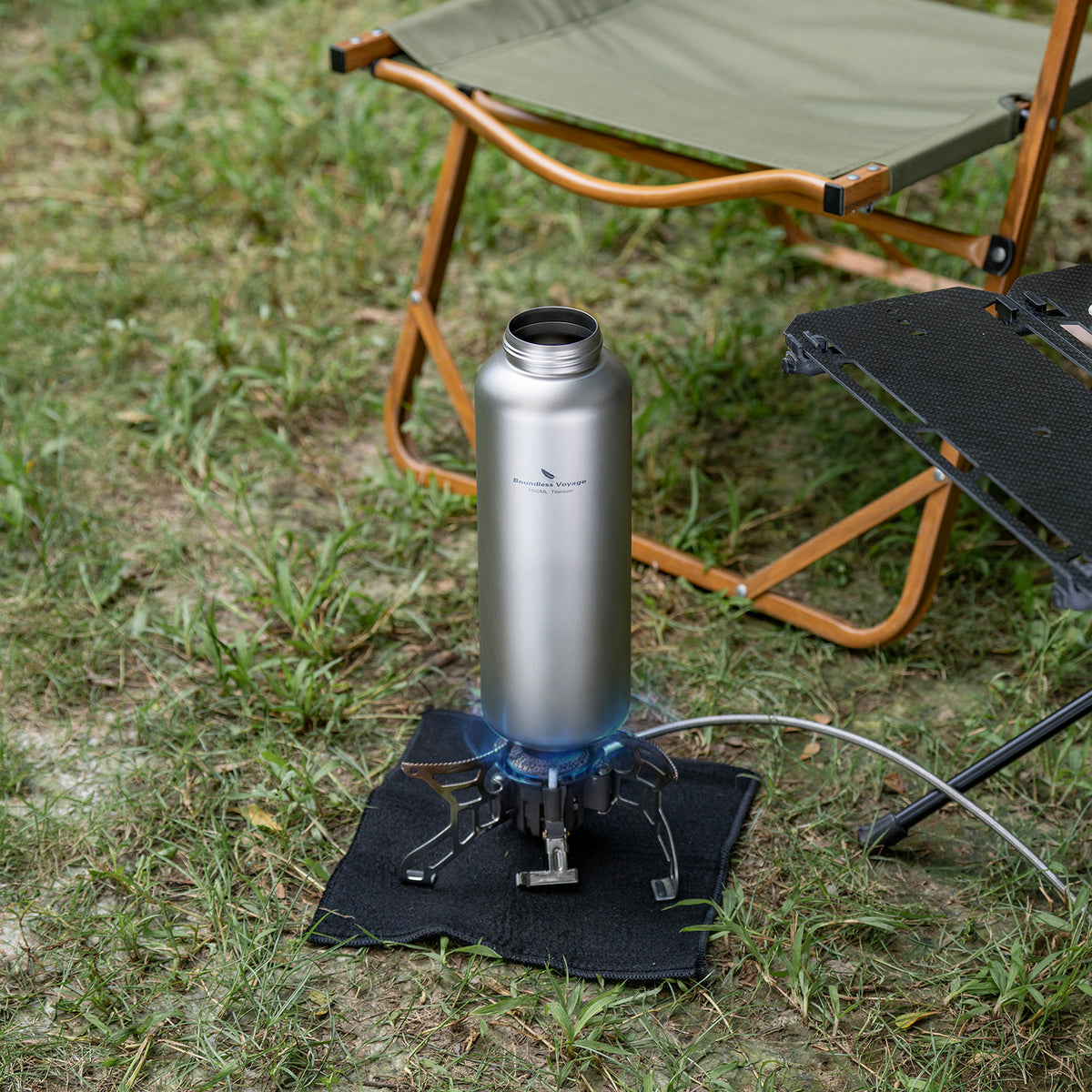 Single-wall titanium water bottle heating water directly on an outdoor camping stove flame