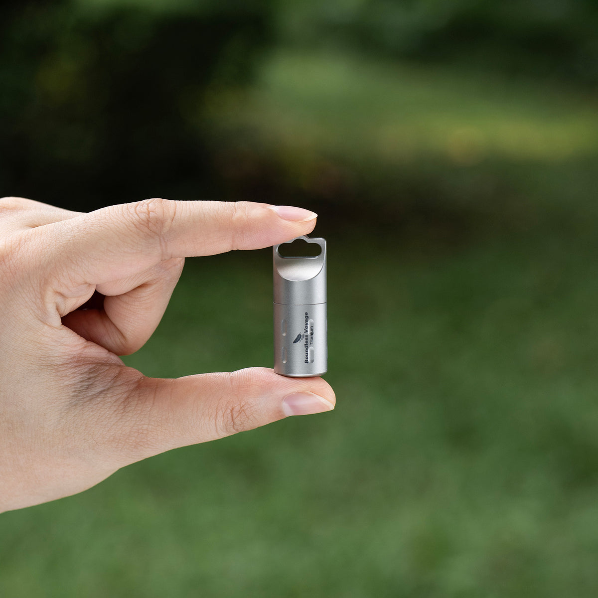Ultralightweight pure titanium pill container held in hand showing compact form factor