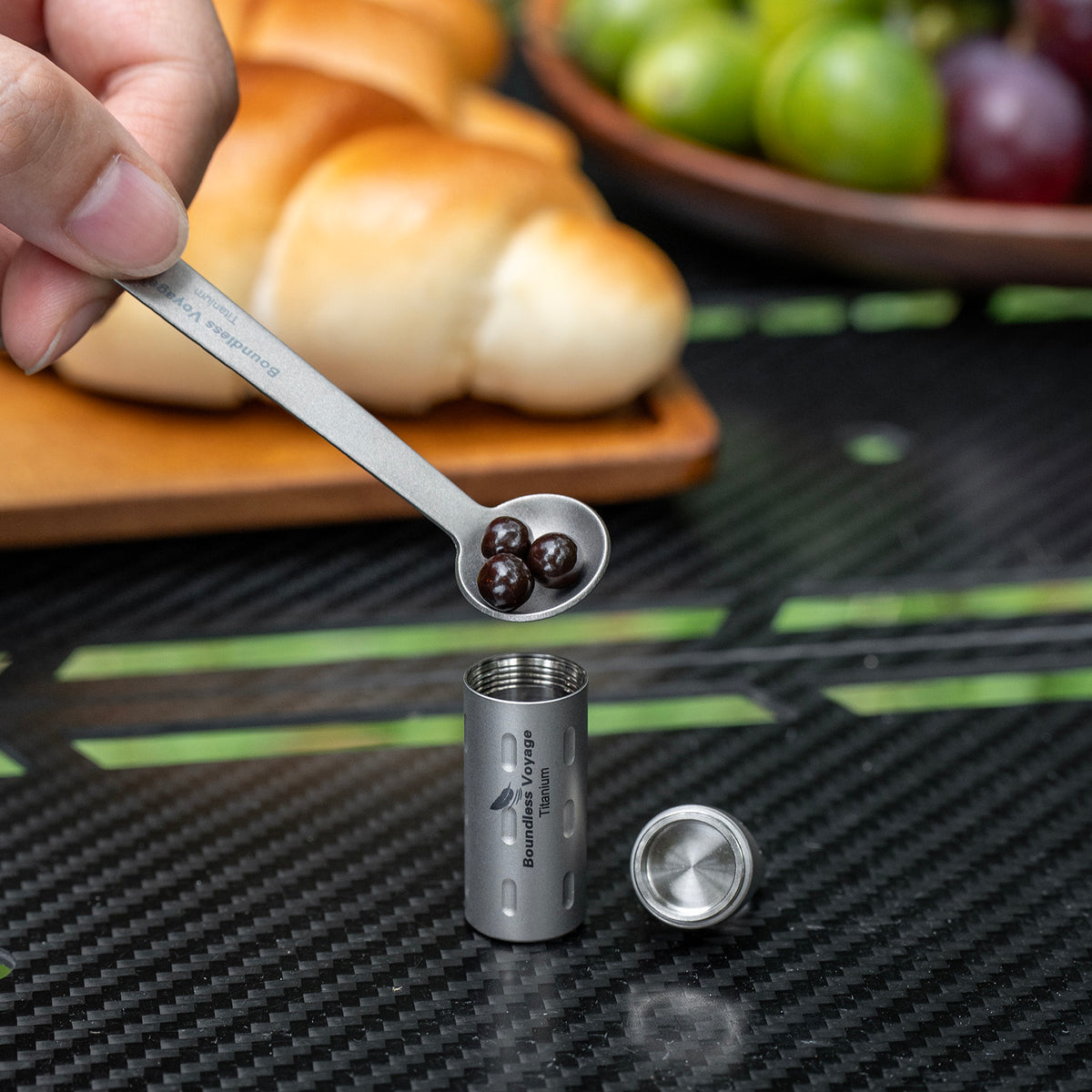 Holding Ti9009B elongated titanium pill case in fingers showing longer pocket size