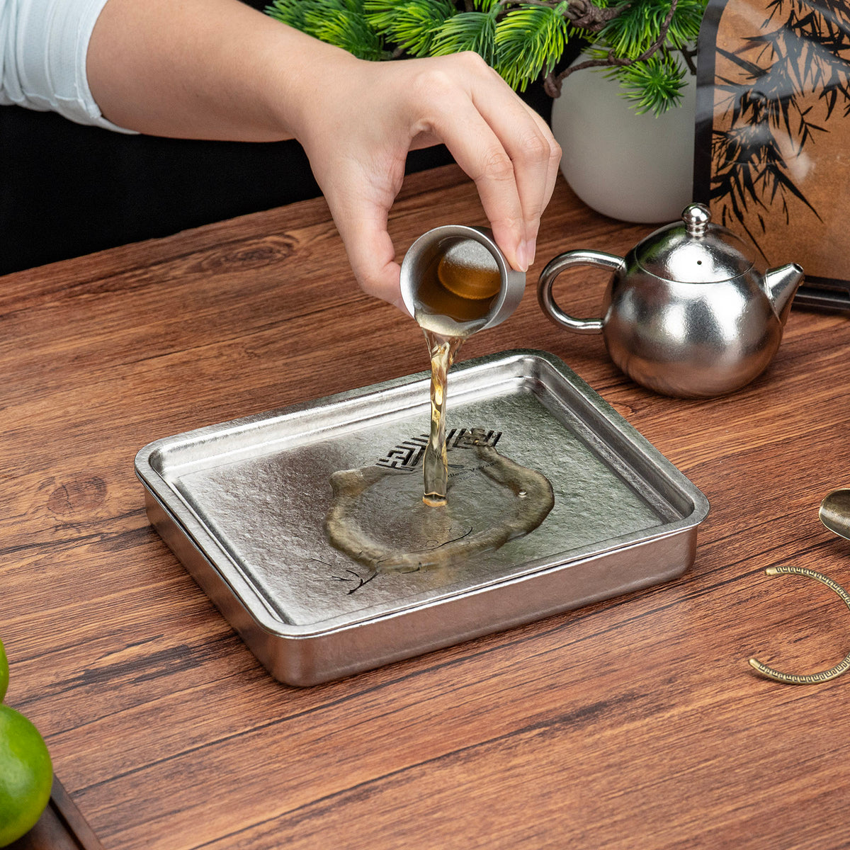 Pouring tea wastewater across the plum blossom cutouts into the lower tray reservoir
