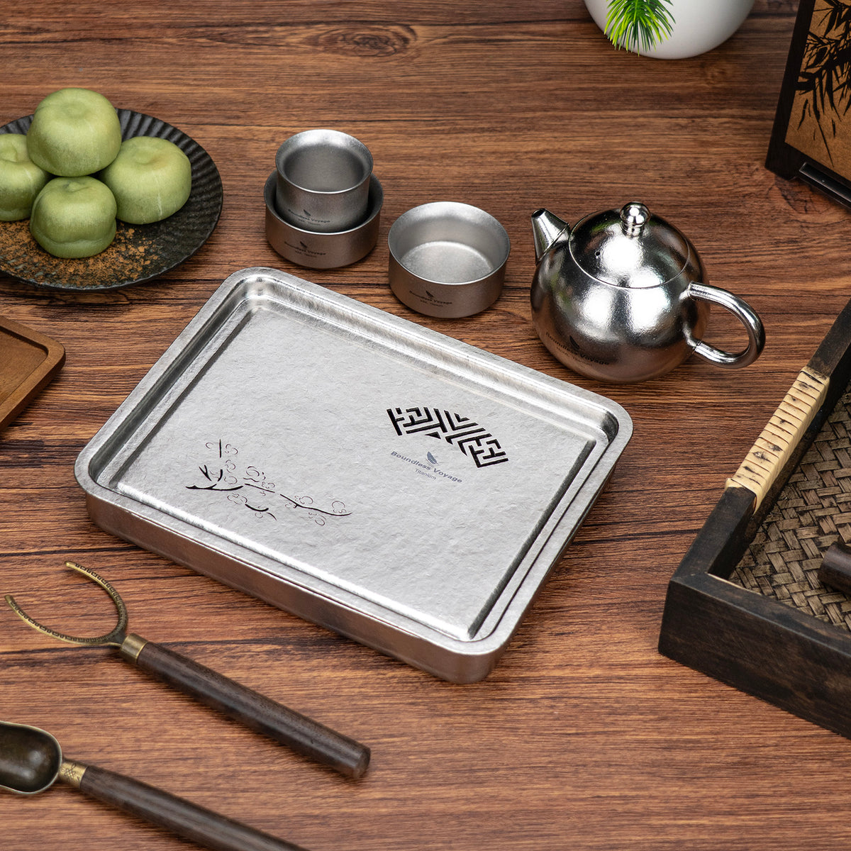 Boundless Voyage titanium tea set arranged with teapot, cups, tea tray, and tea accessories